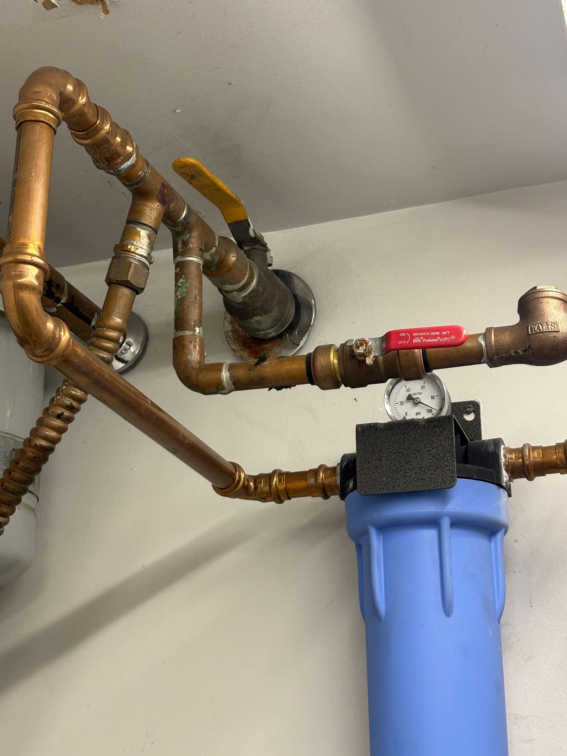 Copper water supply piping and shutoff valves behind a wall