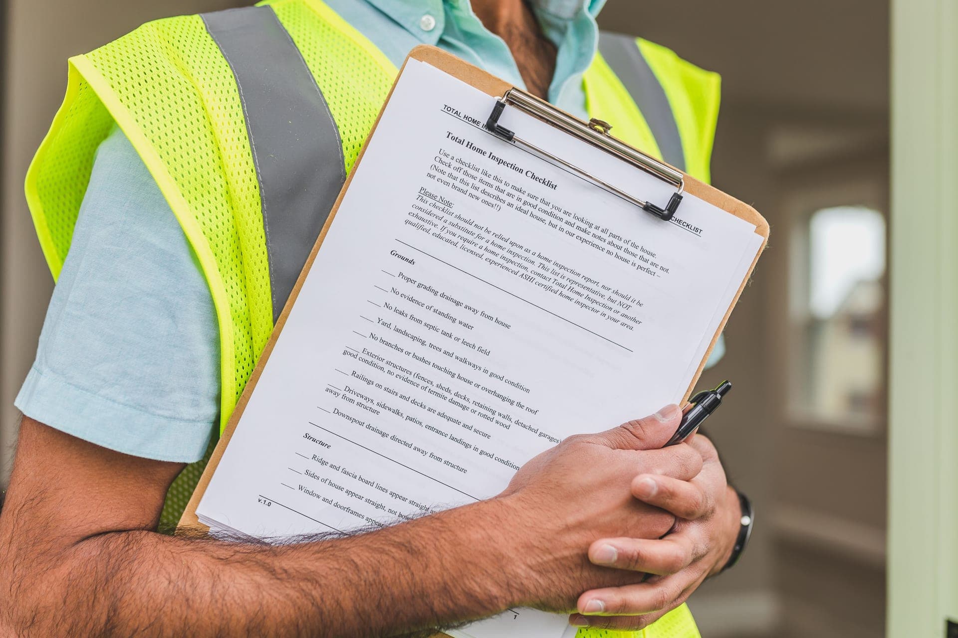 An inspector filling out a damage checklist on a clipboard