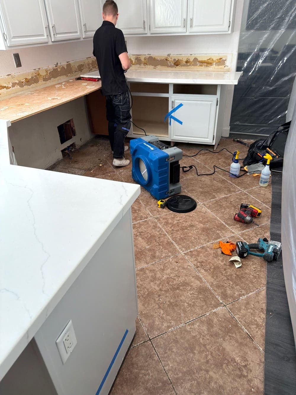 A HEPA air scrubber running in a gutted kitchen during a Resolve Residential Restoration dry-out