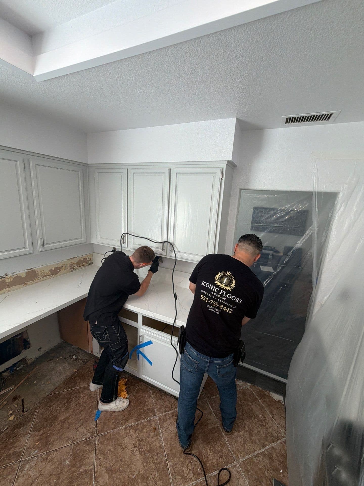 Two Resolve Residential Restoration technicians removing kitchen counter and cabinets during water damage demolition