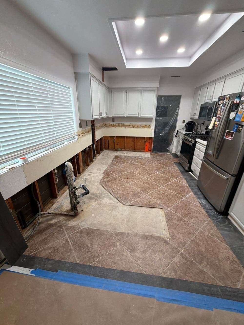 A kitchen stripped back to studs and subfloor, dried and ready to hand over for reconstruction