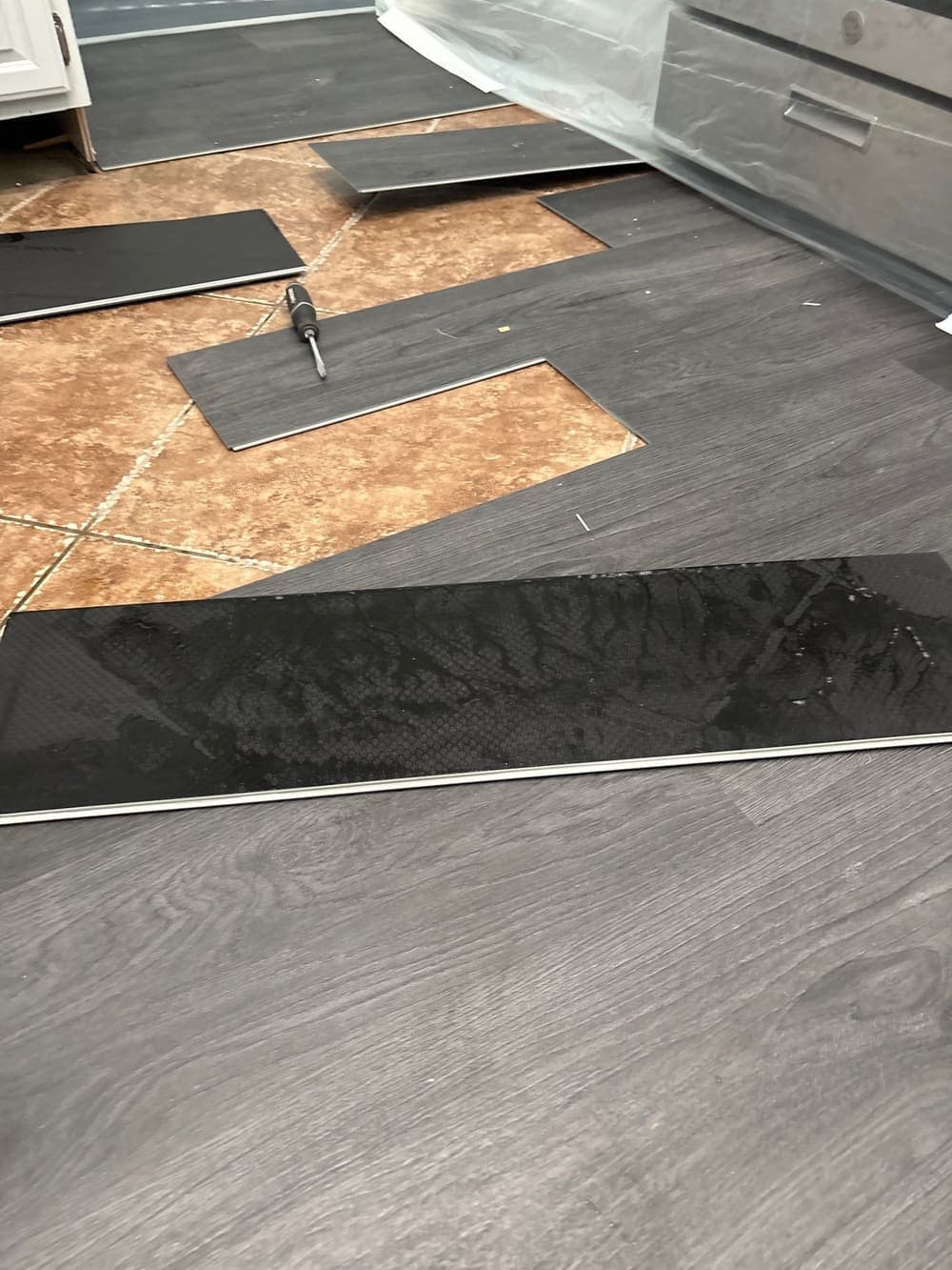 Wet plank flooring lifted away to expose the soaked subfloor beneath