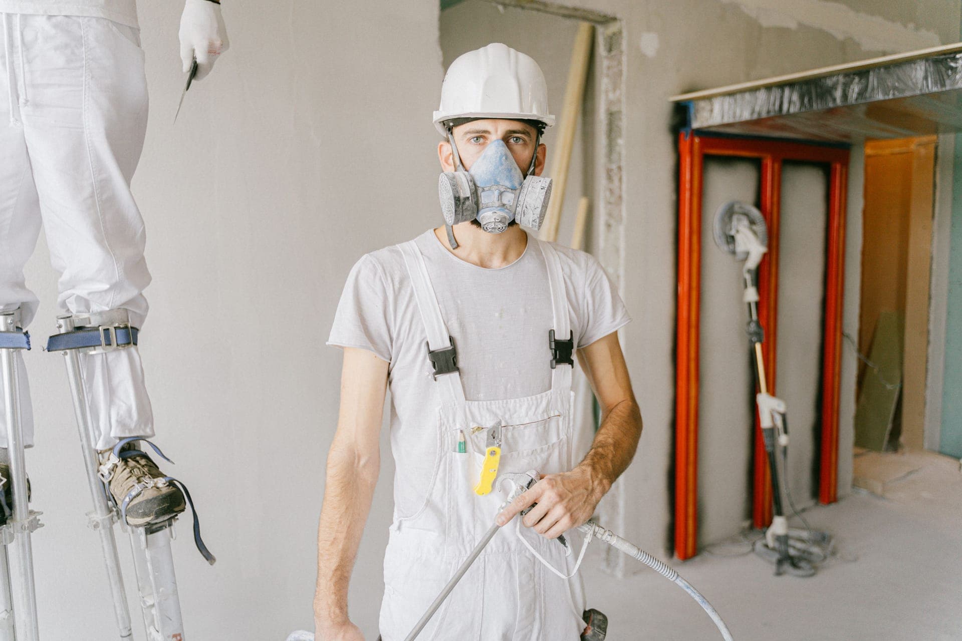 A restoration technician in protective gear working inside a home