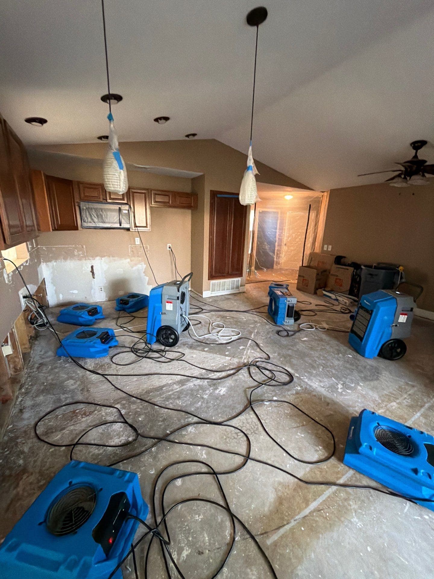 Air movers running in a gutted room sealed off with plastic sheeting