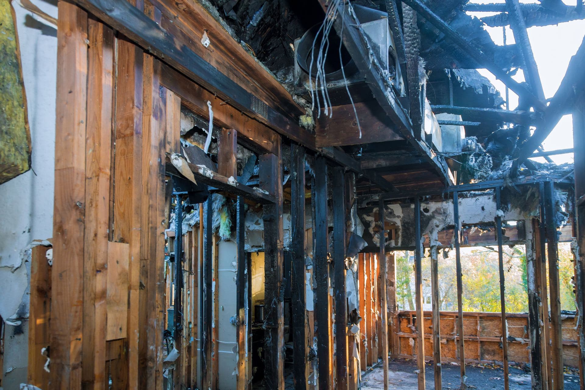 A room with charred wooden walls after a house fire