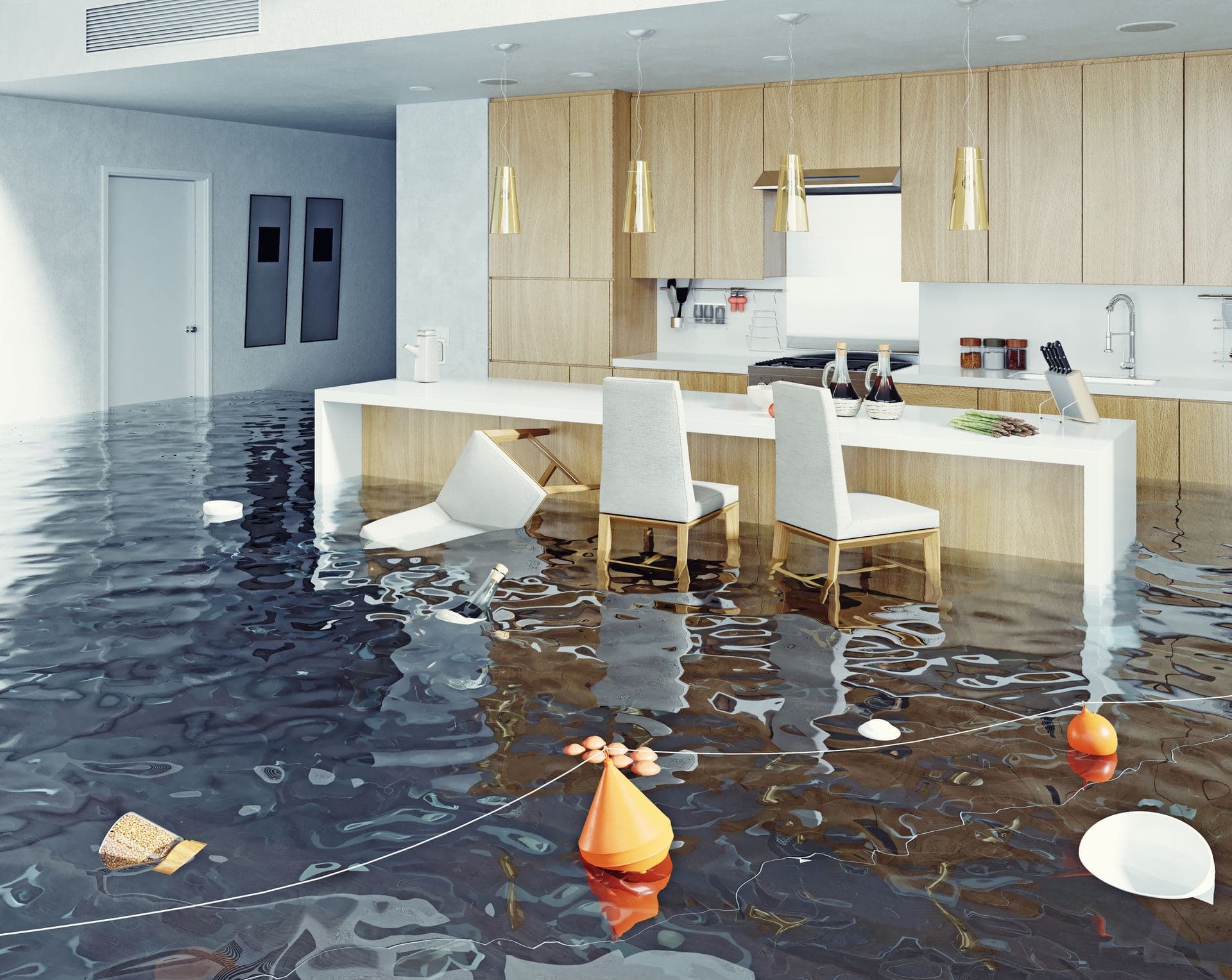 A kitchen actively flooding with water pooling across the floor
