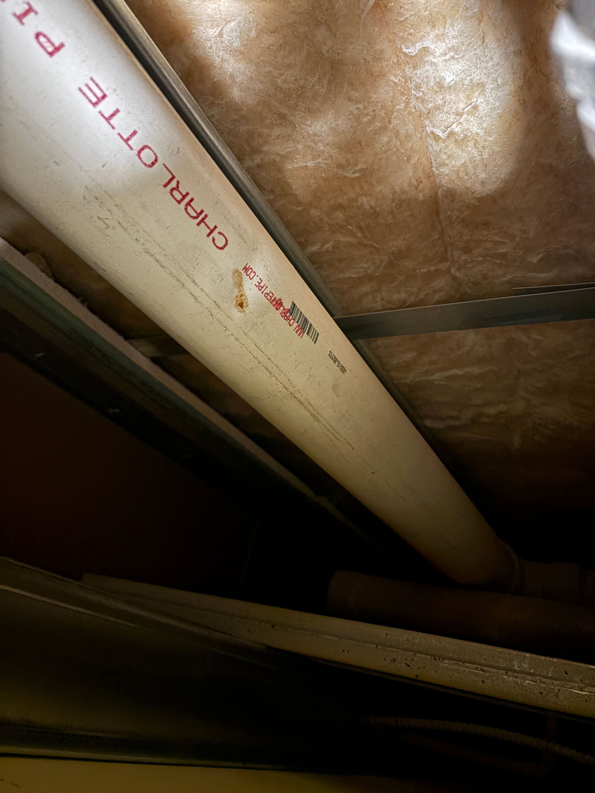 A PVC drain line in a ceiling cavity, a common condensation-leak path