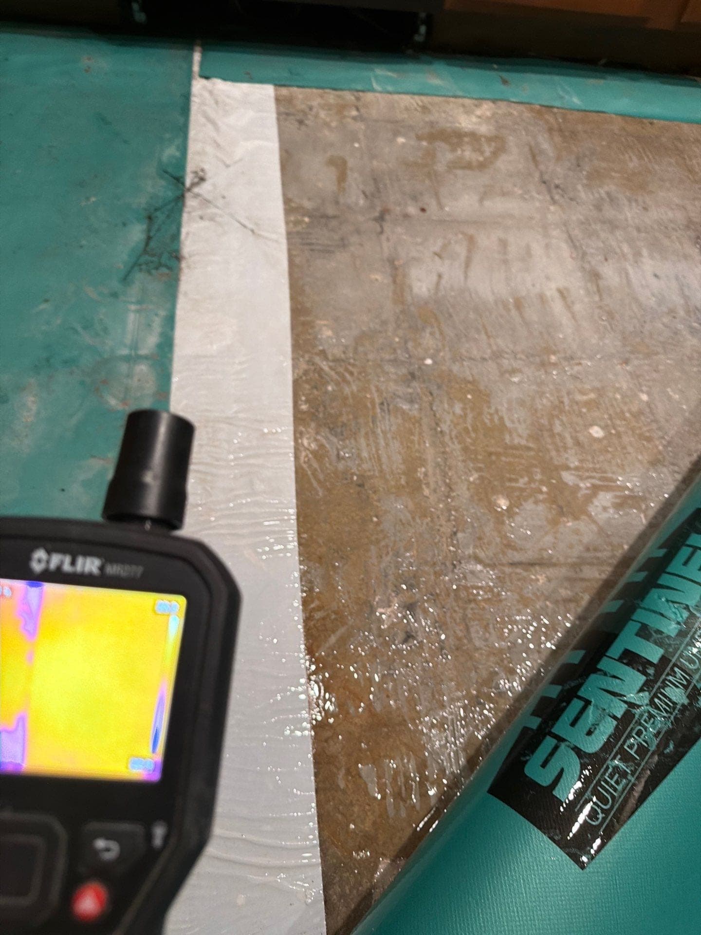 A thermal camera reading moisture in a damp wall