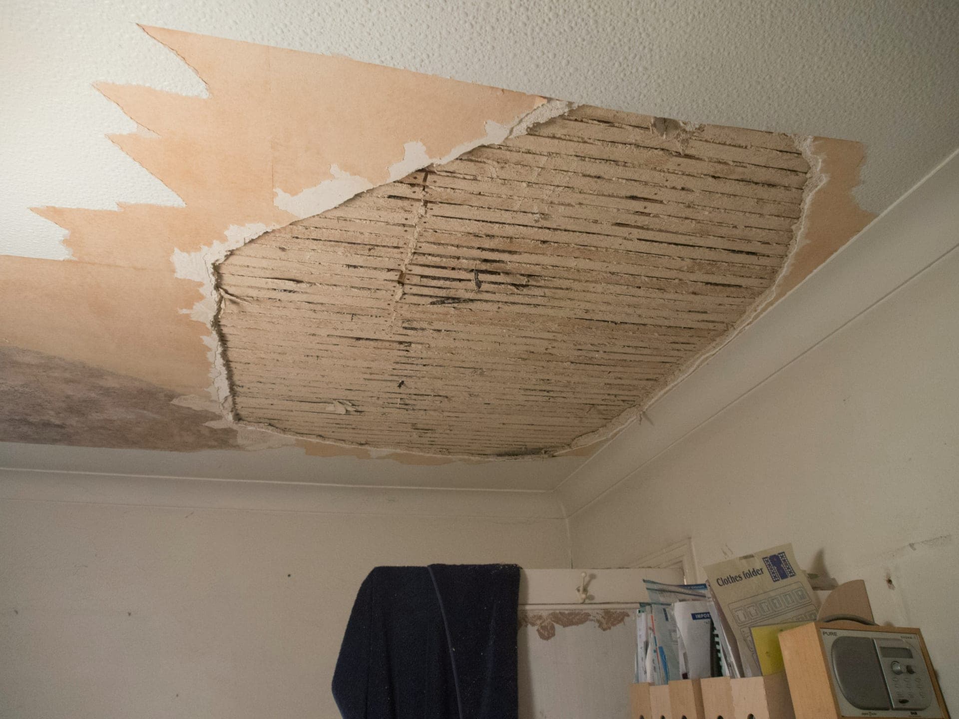 A water-damaged ceiling with peeling plaster in a home