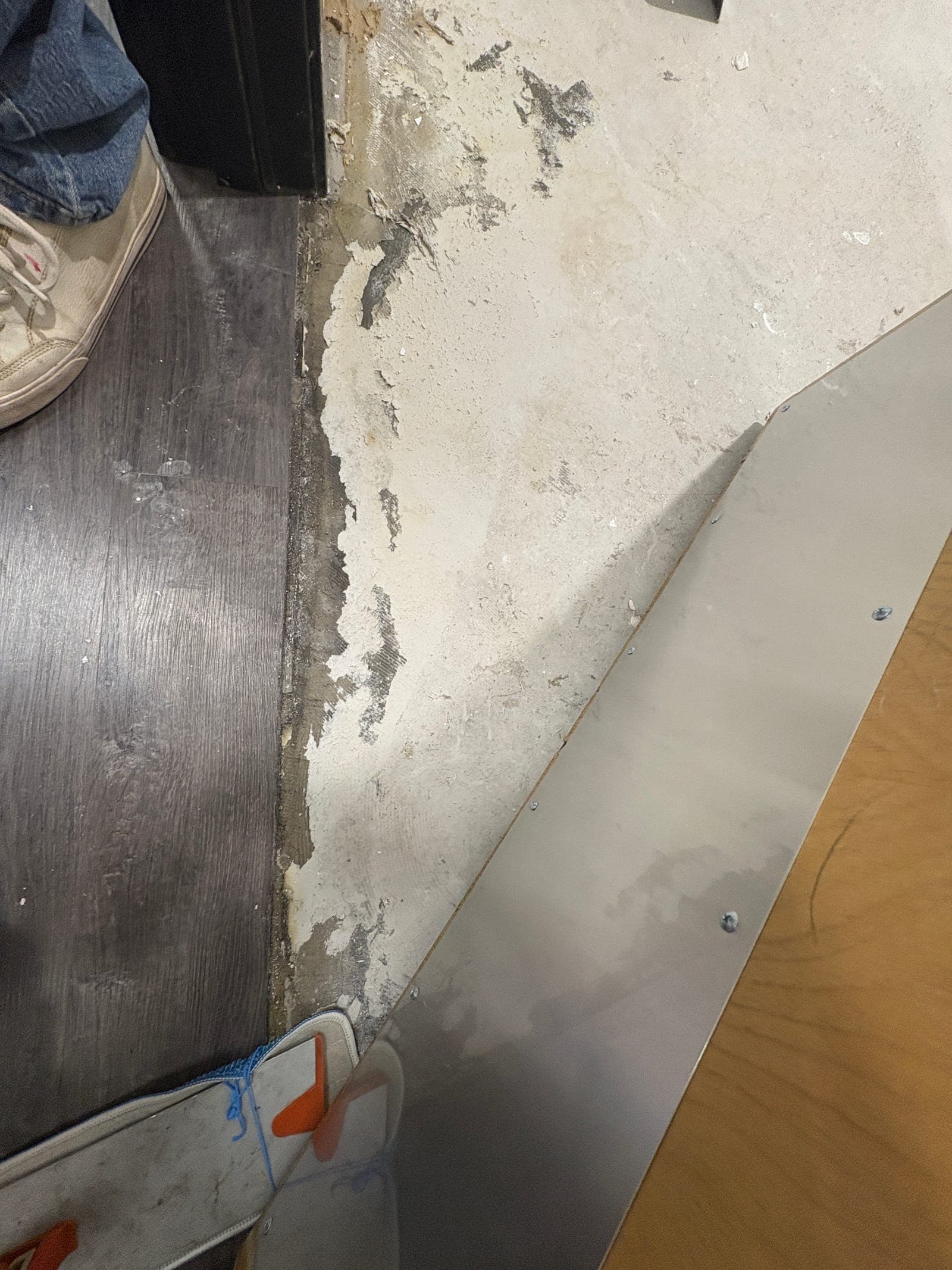 Water-damaged wall base and corner documented on a Resolve Residential Restoration job