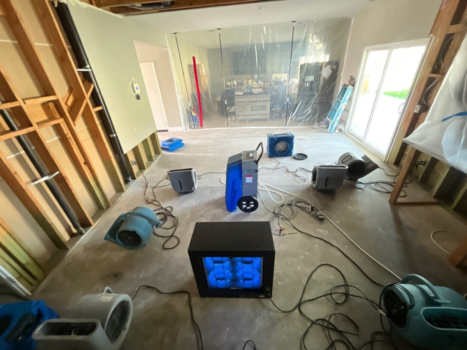 Air movers and power set up to dry a demolished kitchen during a Resolve Residential Restoration job