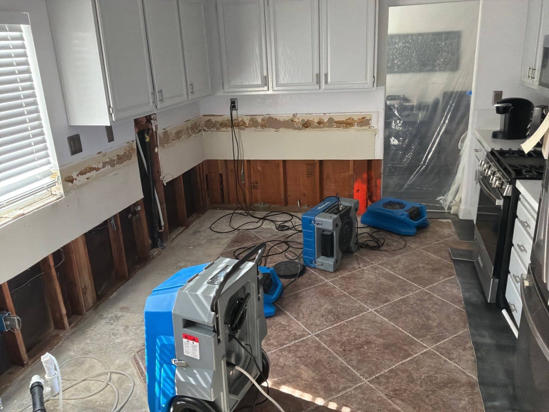 Drying equipment running in a flood-cut kitchen during structural drying.