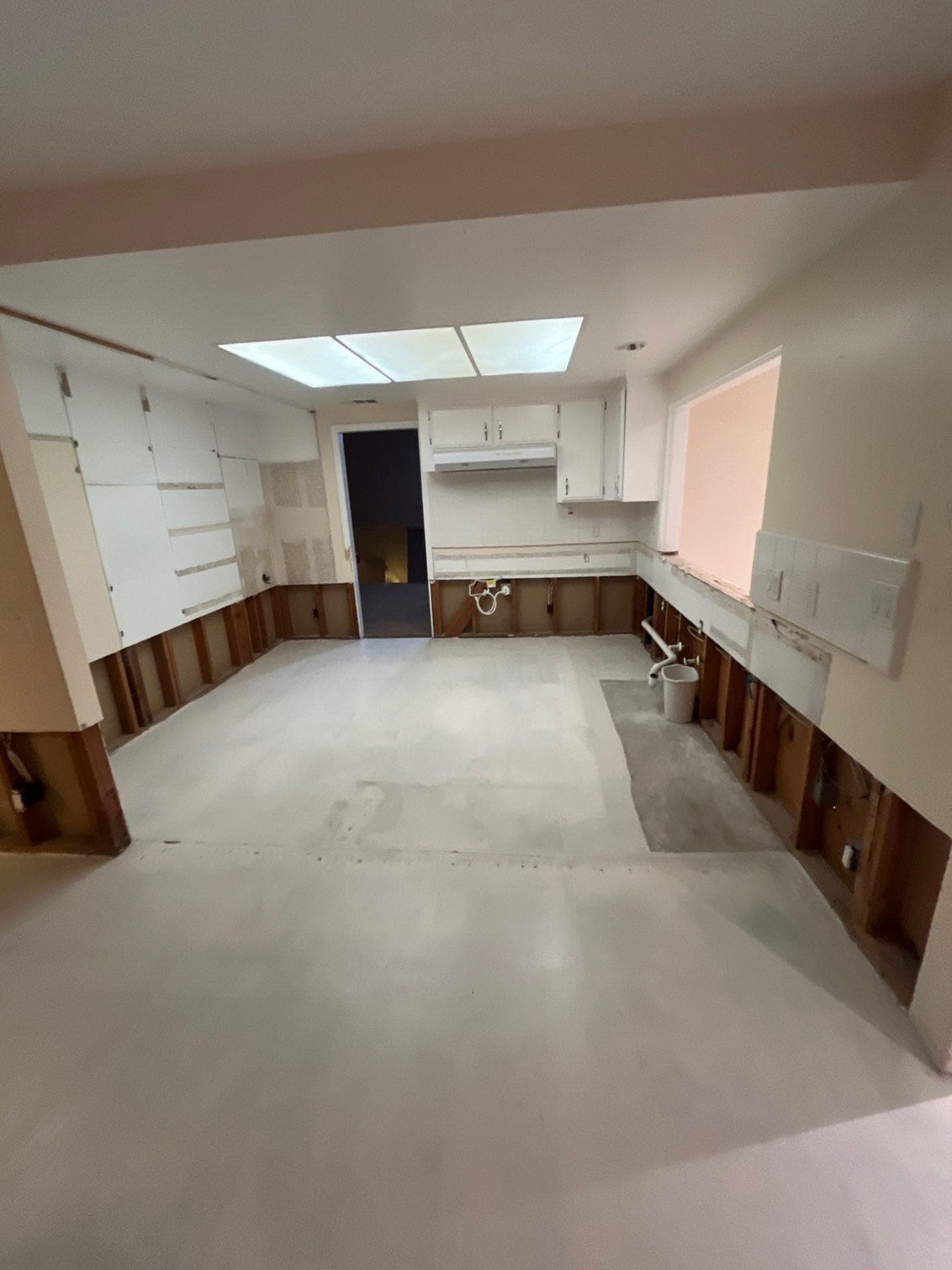 A kitchen stripped of cabinets and flooring, opened up for structural drying by Resolve Residential Restoration