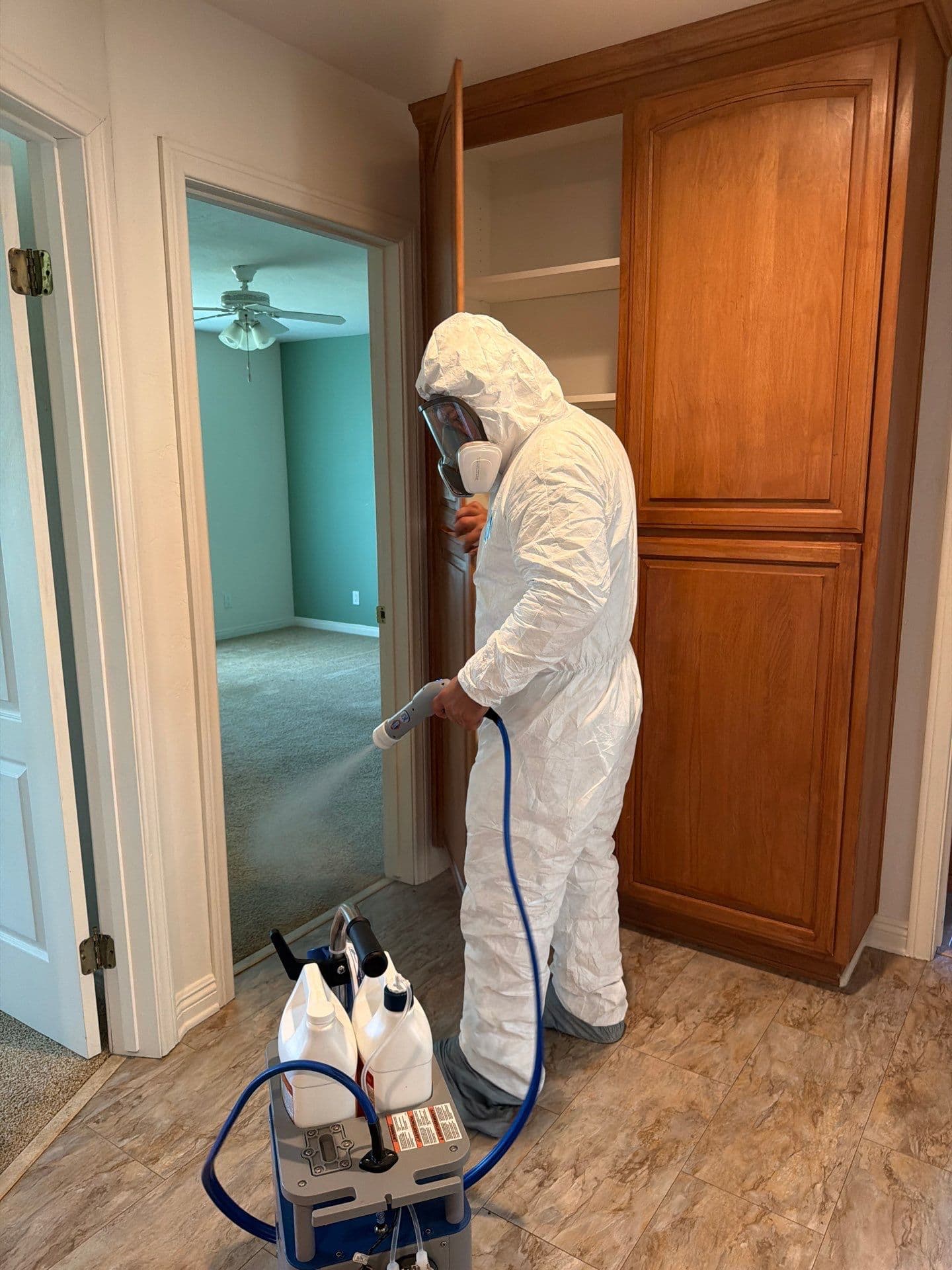 Resolve Residential Restoration technician in hazmat gear performing contained mold treatment