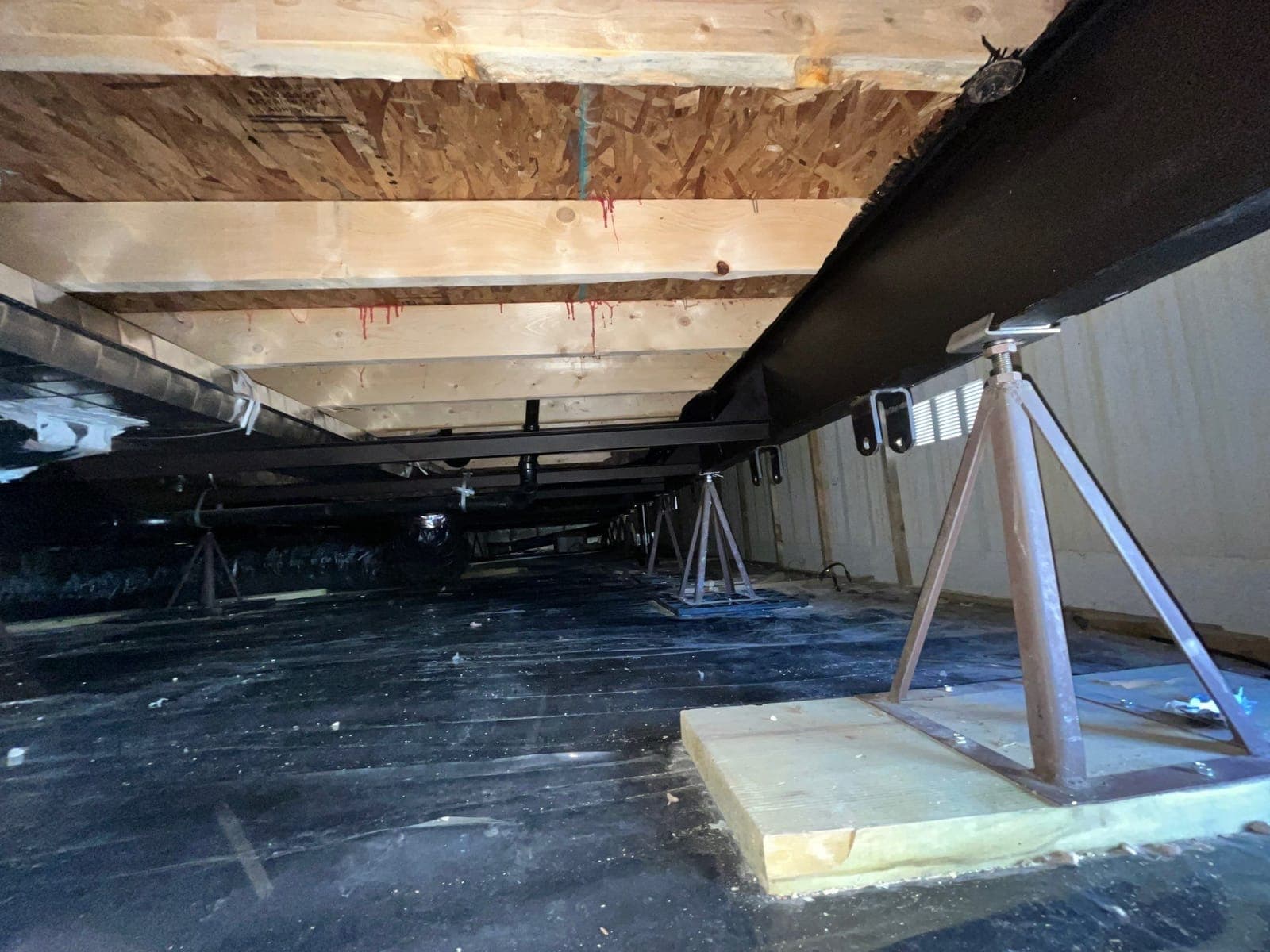 Structural jacks and a moisture membrane in a crawlspace during a Resolve Residential Restoration dry-out