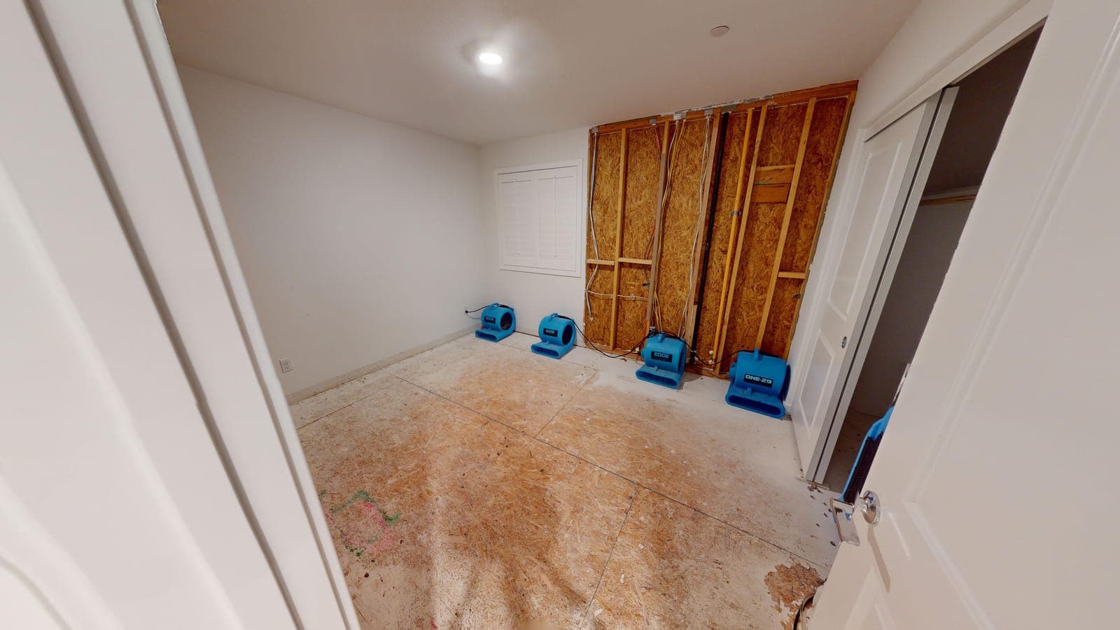 A room opened to the wall studs with air movers running during a Resolve Residential Restoration dry-out